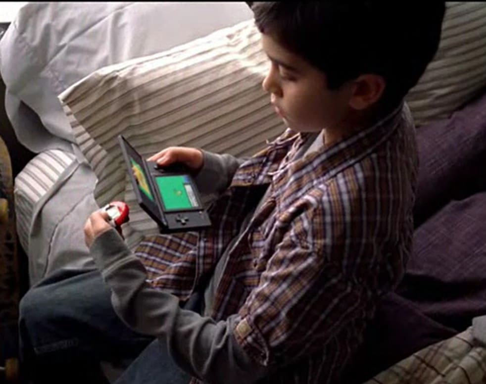 A boy is playing with an electronic device.